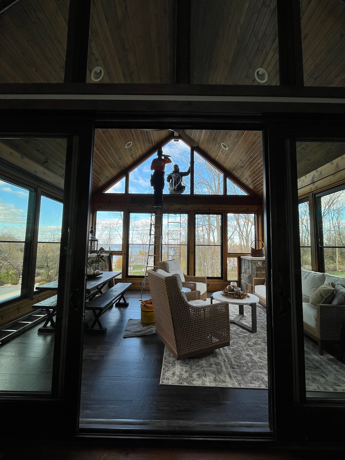 Rope access technician cleaning high windows in modern home